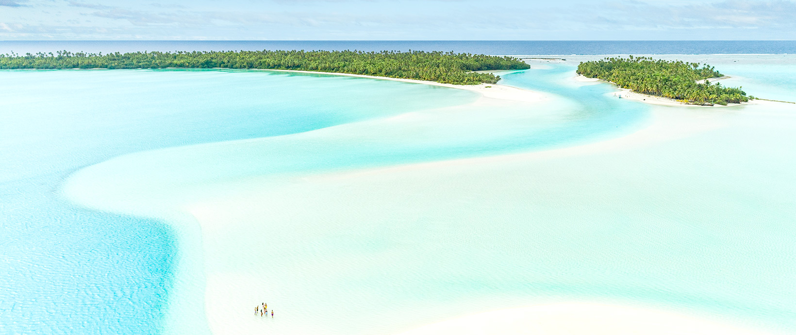 A group of Paul Gauguin Cruises guests enjoying leisure time on Aitutaki lagoon.