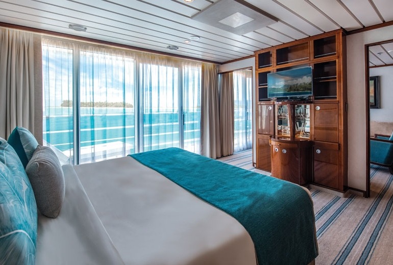 Bedroom view of Owner's Suite #701 aboard the luxury small-shop m/s Paul Gauguin