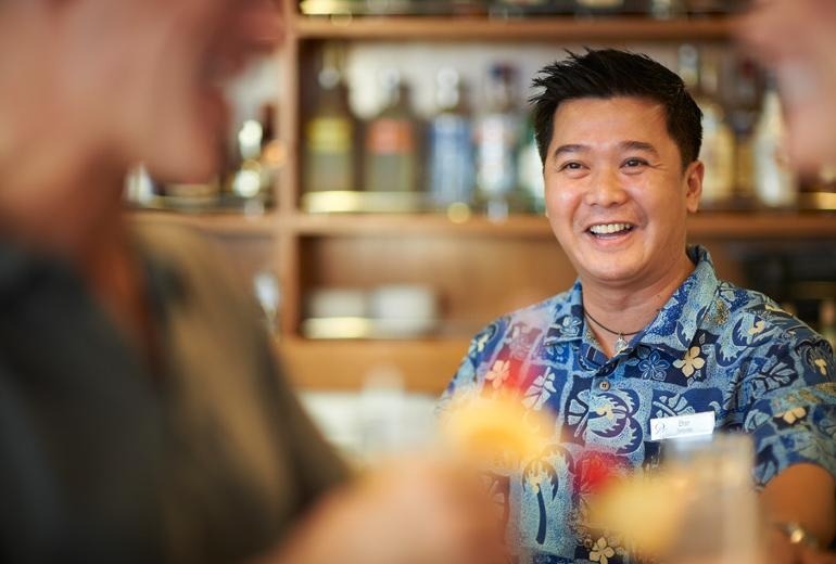 A bartender providing quality service to a guest of the m/s Paul Gauguin.